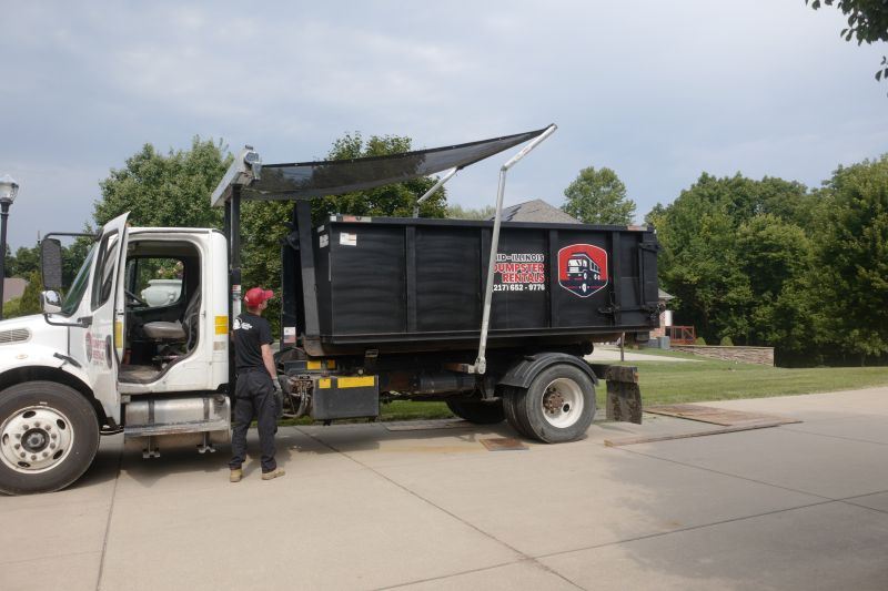 dumpster driver placing tarp on top of full dumpster